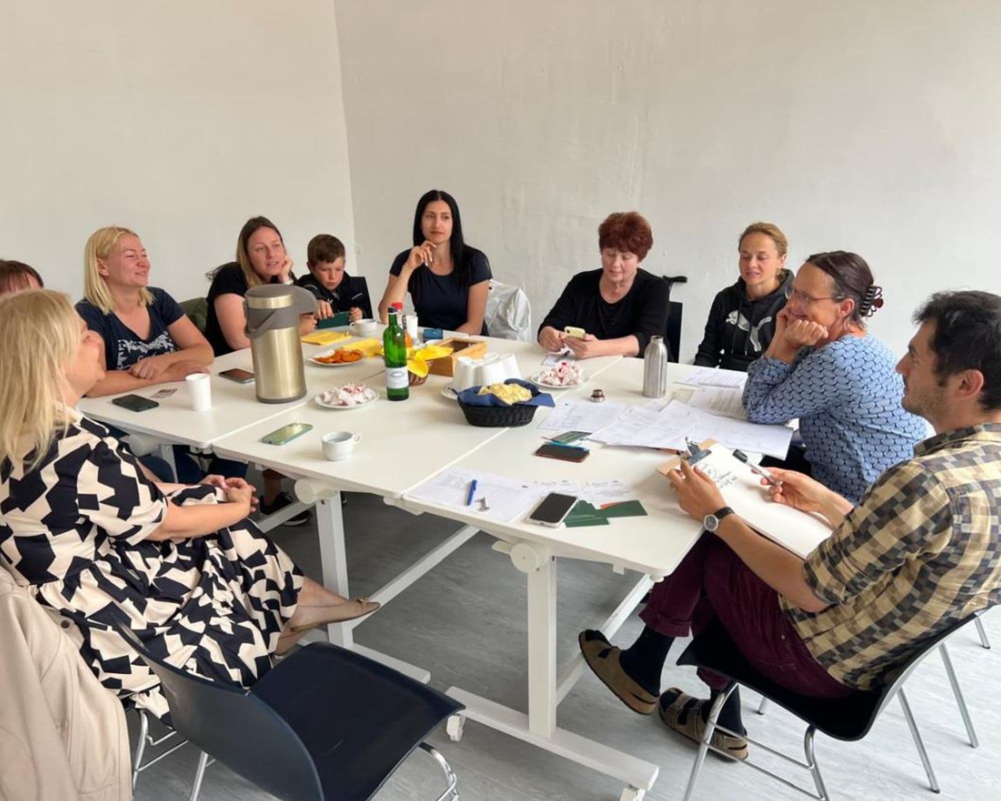 Mehrere Personen sitzen am Tisch und sprechen miteinander.